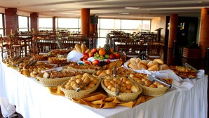 A buffet table with various food items and bread baskets. - Natal Praia Hotel (Natal)