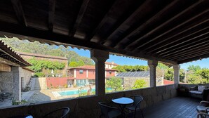 A covered outdoor area with a pool, stone walls, and outdoor seating. - Hotel Alves (Braga)