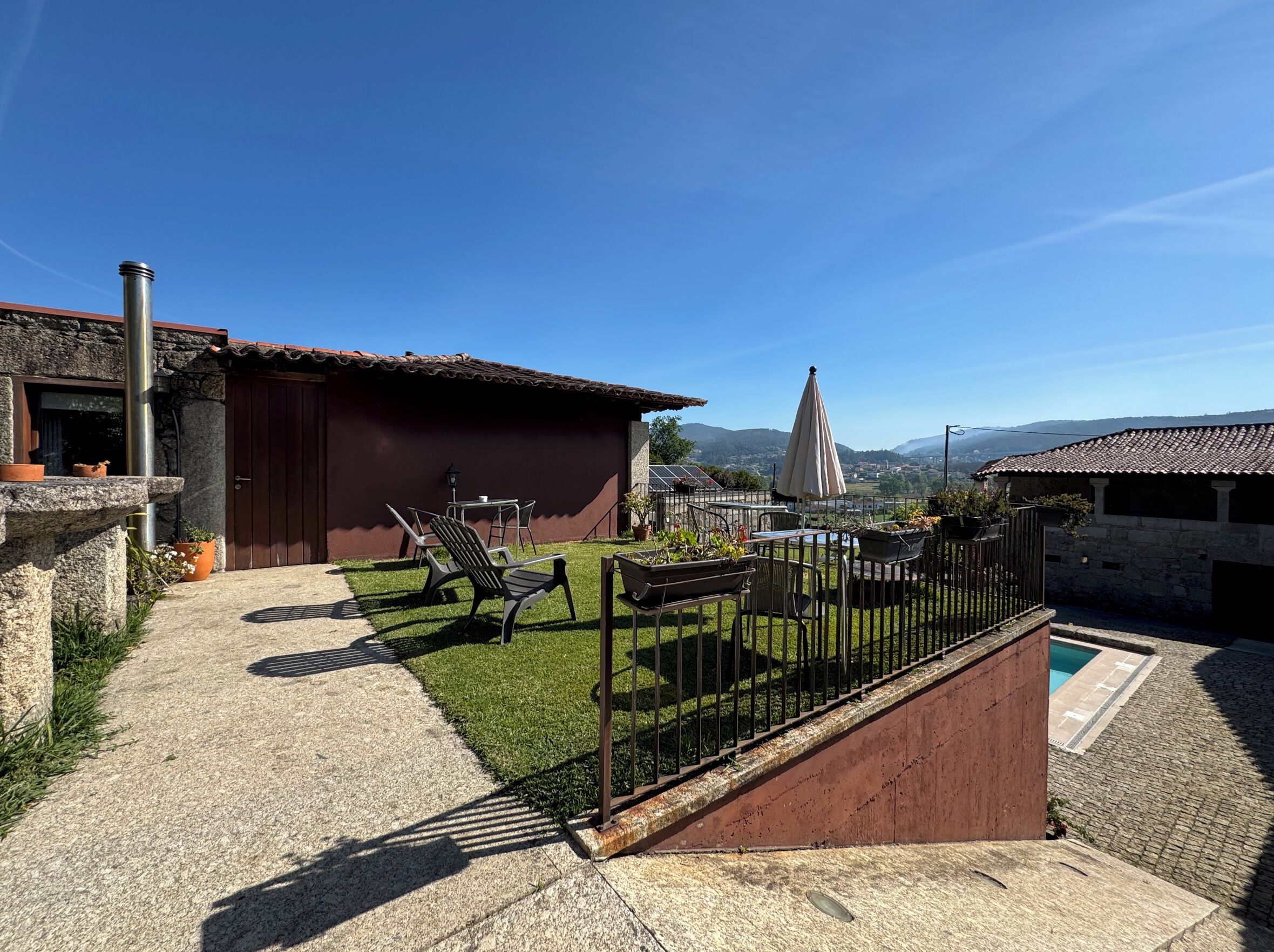 Une cour avec une piscine, un espace salon extérieur et une vue sur les montagnes lointaines.