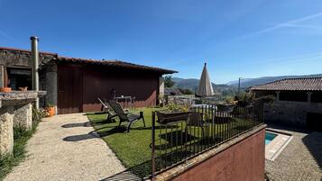 Une cour avec une piscine, un espace salon extérieur et une vue sur les montagnes lointaines.