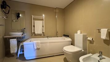 Un baño moderno con bañera, inodoro, lavabo y espejo.