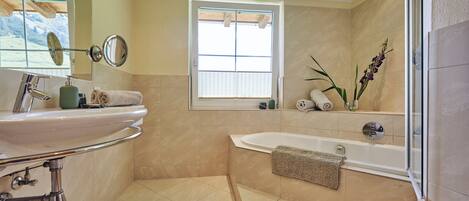 Un baño moderno con un lavamanos grande, una bañera y una ventana con vistas.