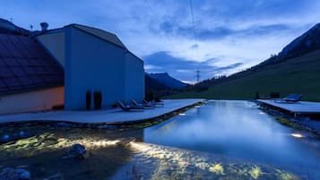 Een buitenzwembad, parasols voor strand/zwembad