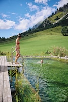 Una piscina al aire libre, sombrillas, tumbonas