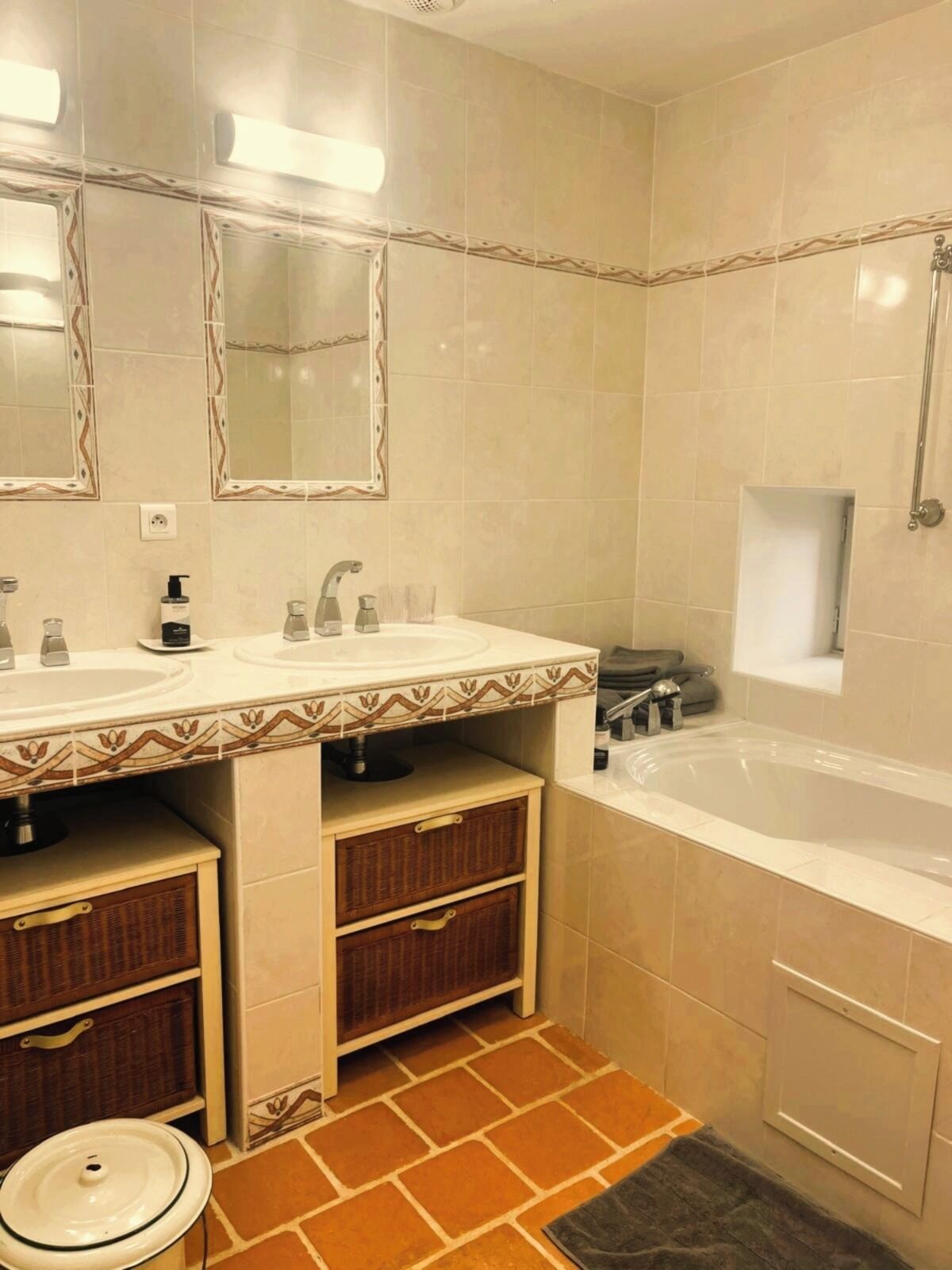 Une salle de bain avec deux lavabos, une baignoire, des toilettes et un miroir.