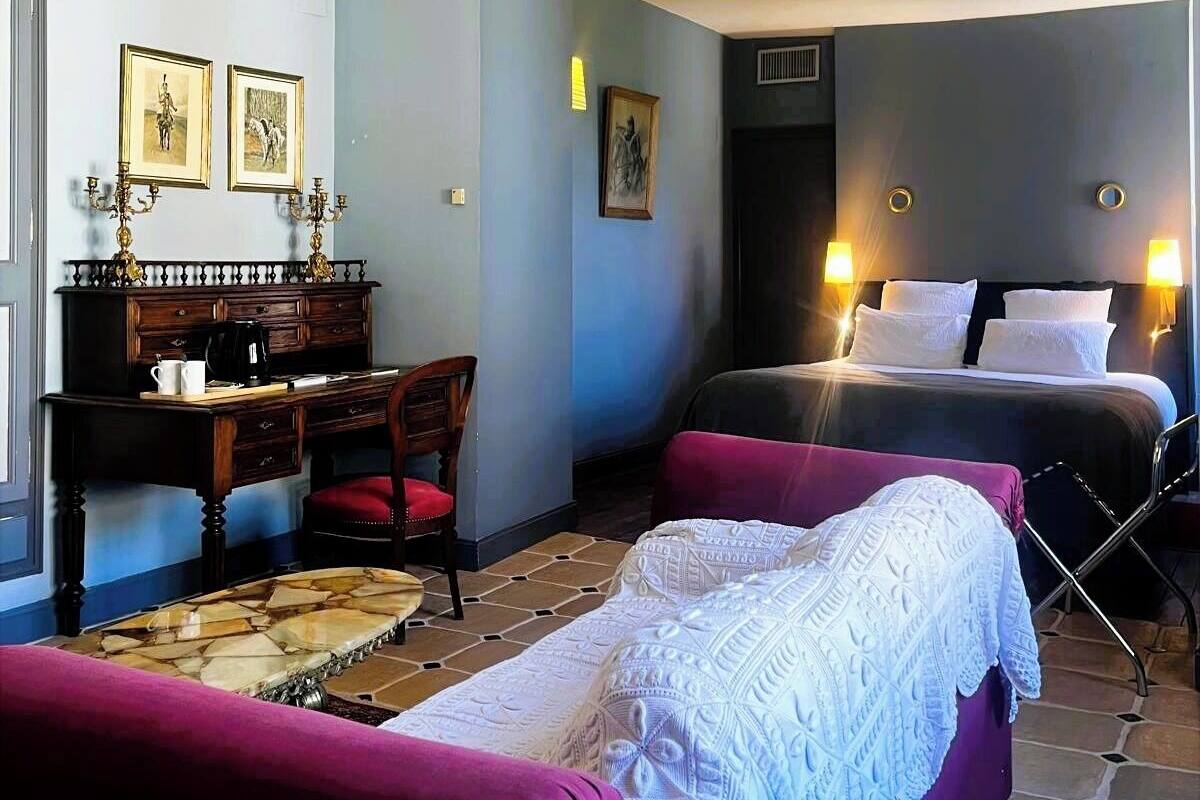 Een kamer met een bed, een bureau, een stoel en een bank.