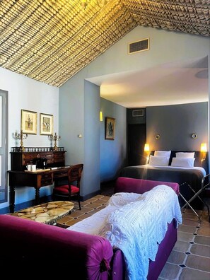 A room with a bed, a desk, a chair, and a couch.