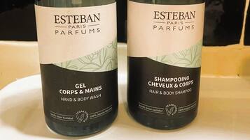 Kaksi pulloa Esteban Paris Parfums -merkkiä olevaa hiusten- ja vartalonpesuainetta valkoisella alustalla.
