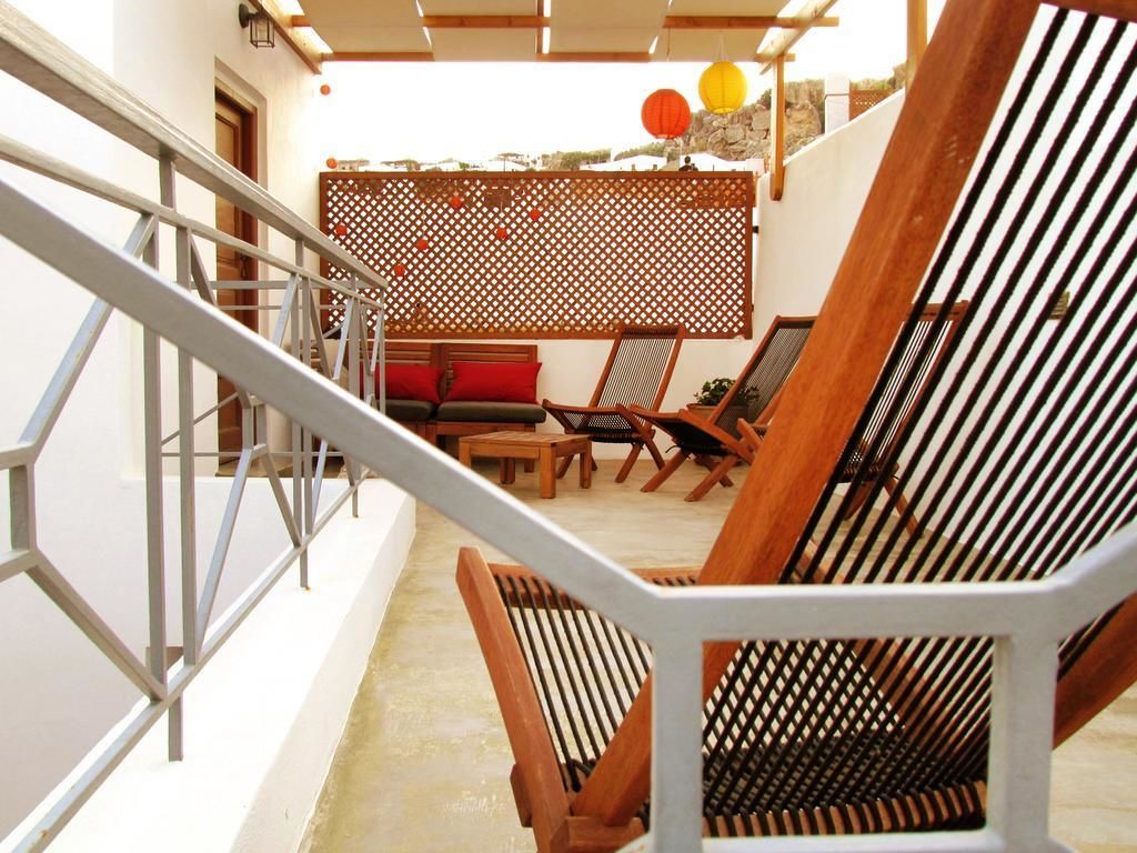 A staircase leading to a balcony with wooden chairs and a table.