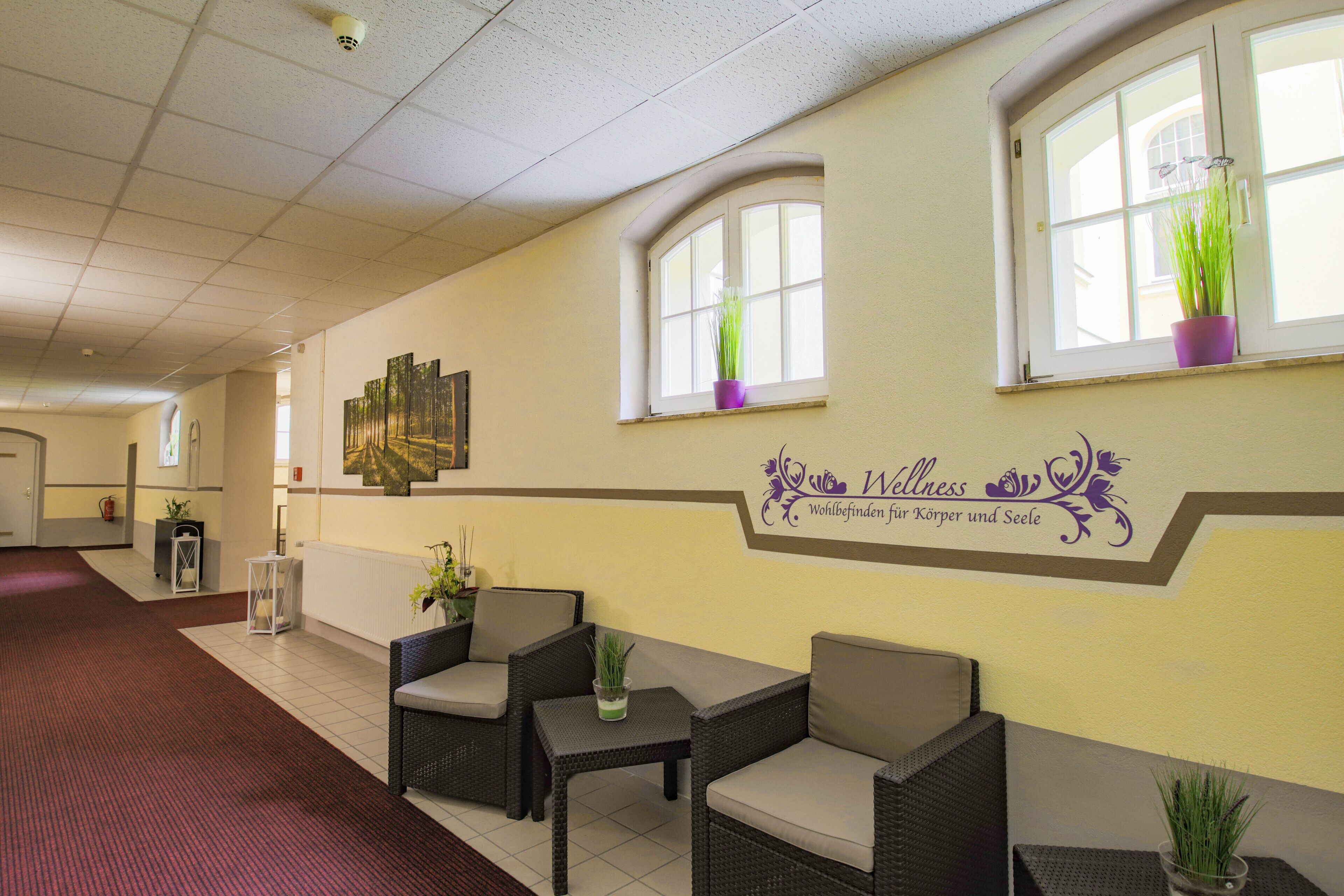 A reception area with wicker furniture, a reception desk, and a wall-mounted sign.