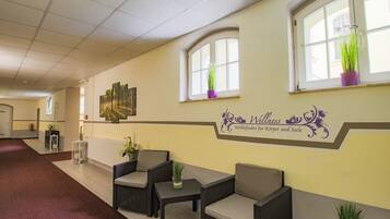 A reception area with wicker furniture, a reception desk, and a wall-mounted sign.