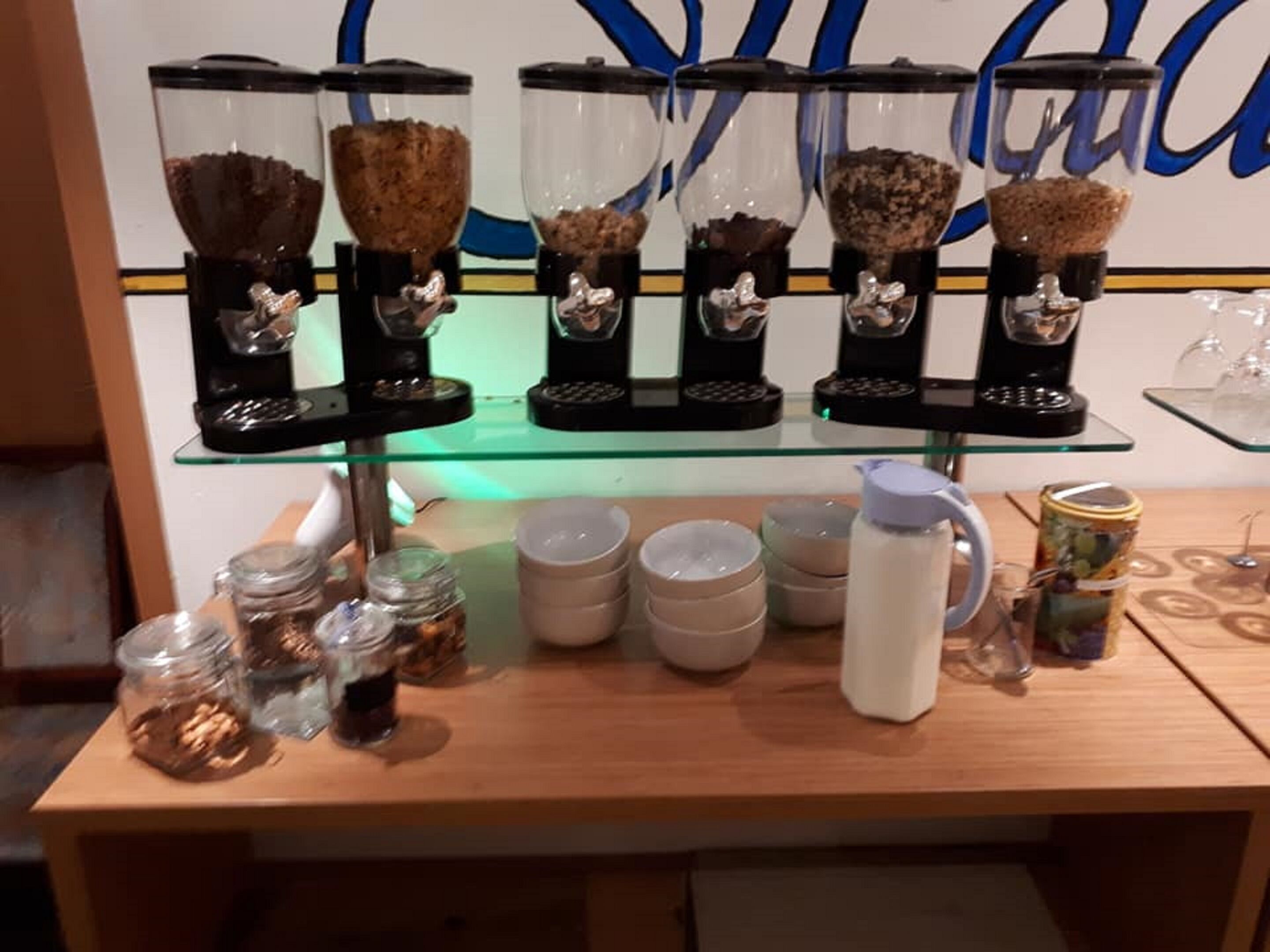A coffee station with multiple dispensers and various containers of coffee and cream.