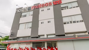 Un hôtel appelé « mateos 1215 », doté d’un design moderne, avec une enseigne bien visible et un numéro de téléphone pour les réservations.