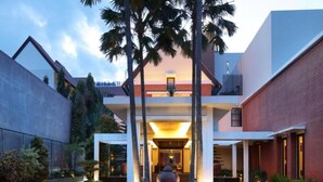 A modern building with a central courtyard, a large vase, and a staircase leading to an upper level.