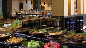 A buffet area with various dishes displayed on tables, a bar area with bottles, and a modern interior with pendant lighting.
