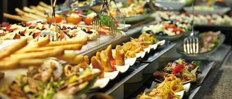 A buffet with various dishes and utensils.