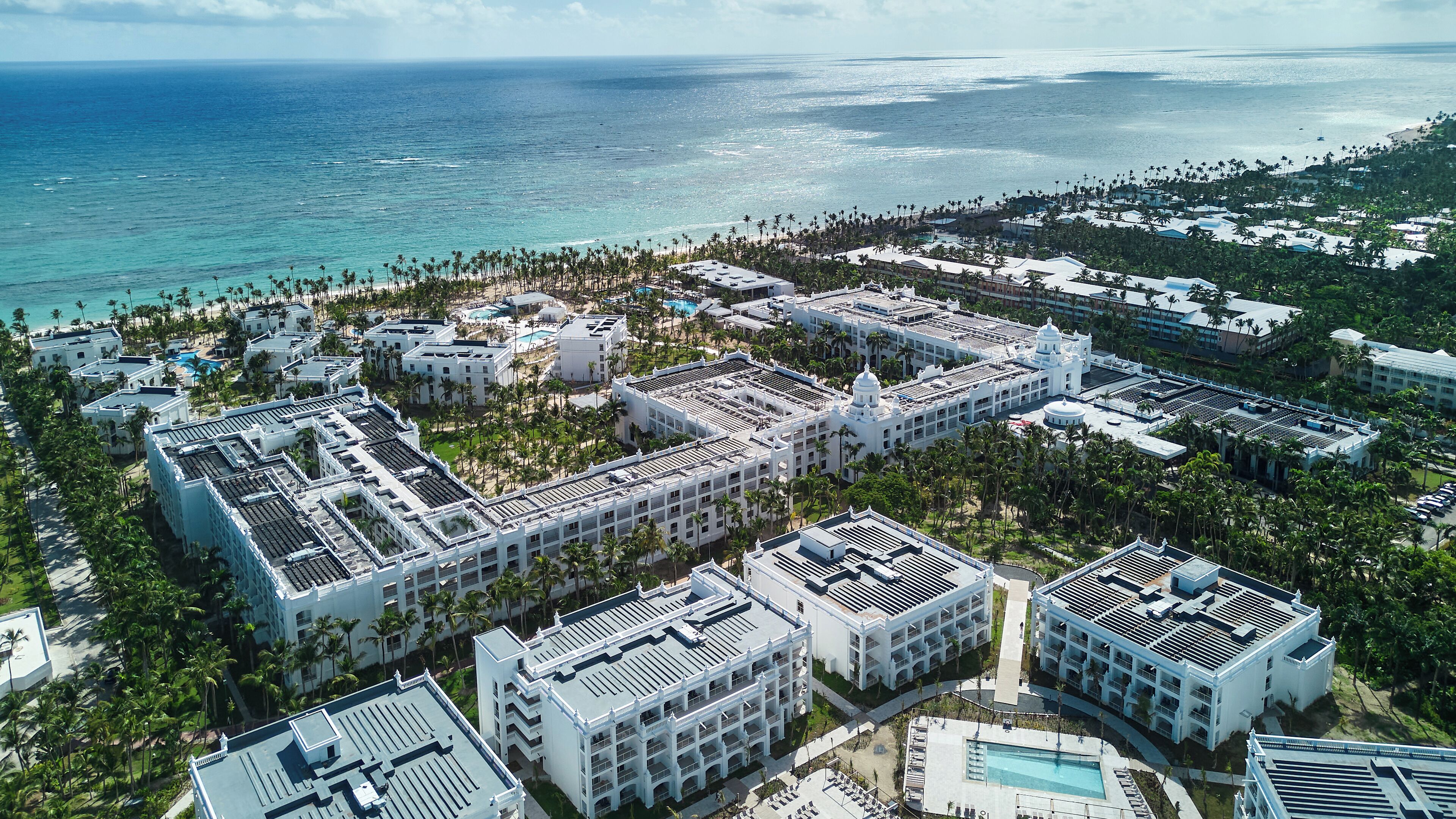 A resort with multiple buildings, a pool, and a beach.