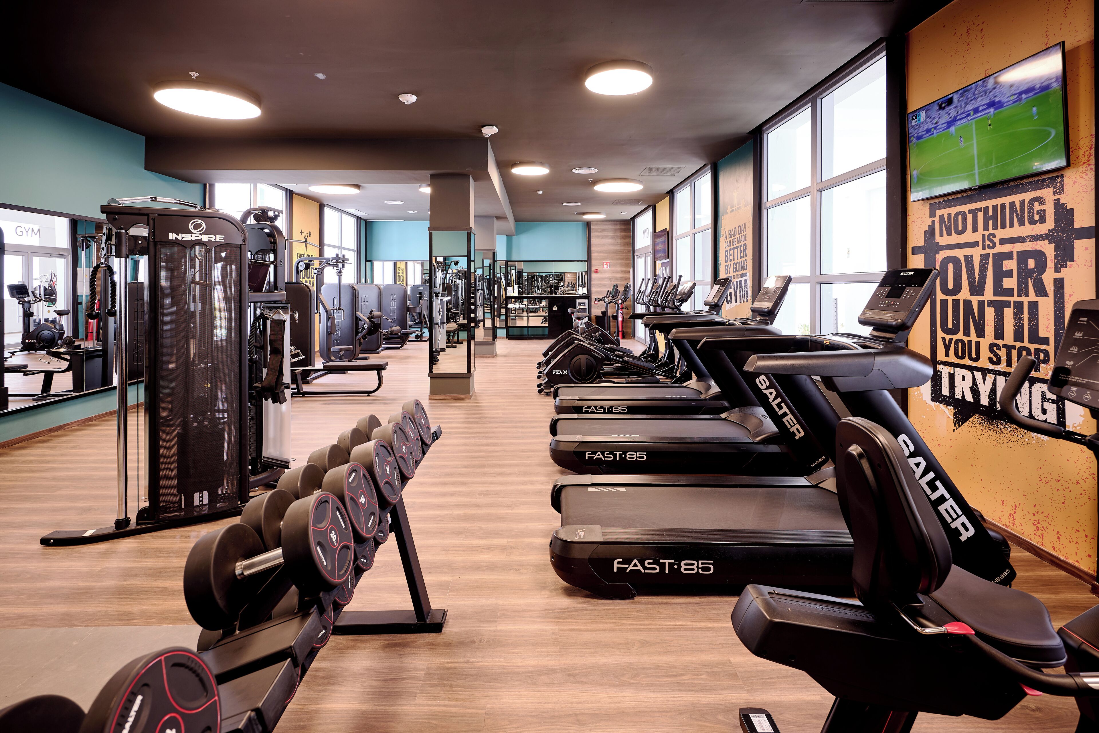 Ein Fitnessstudio mit Laufbändern, Hanteln und Kraftgeräten.