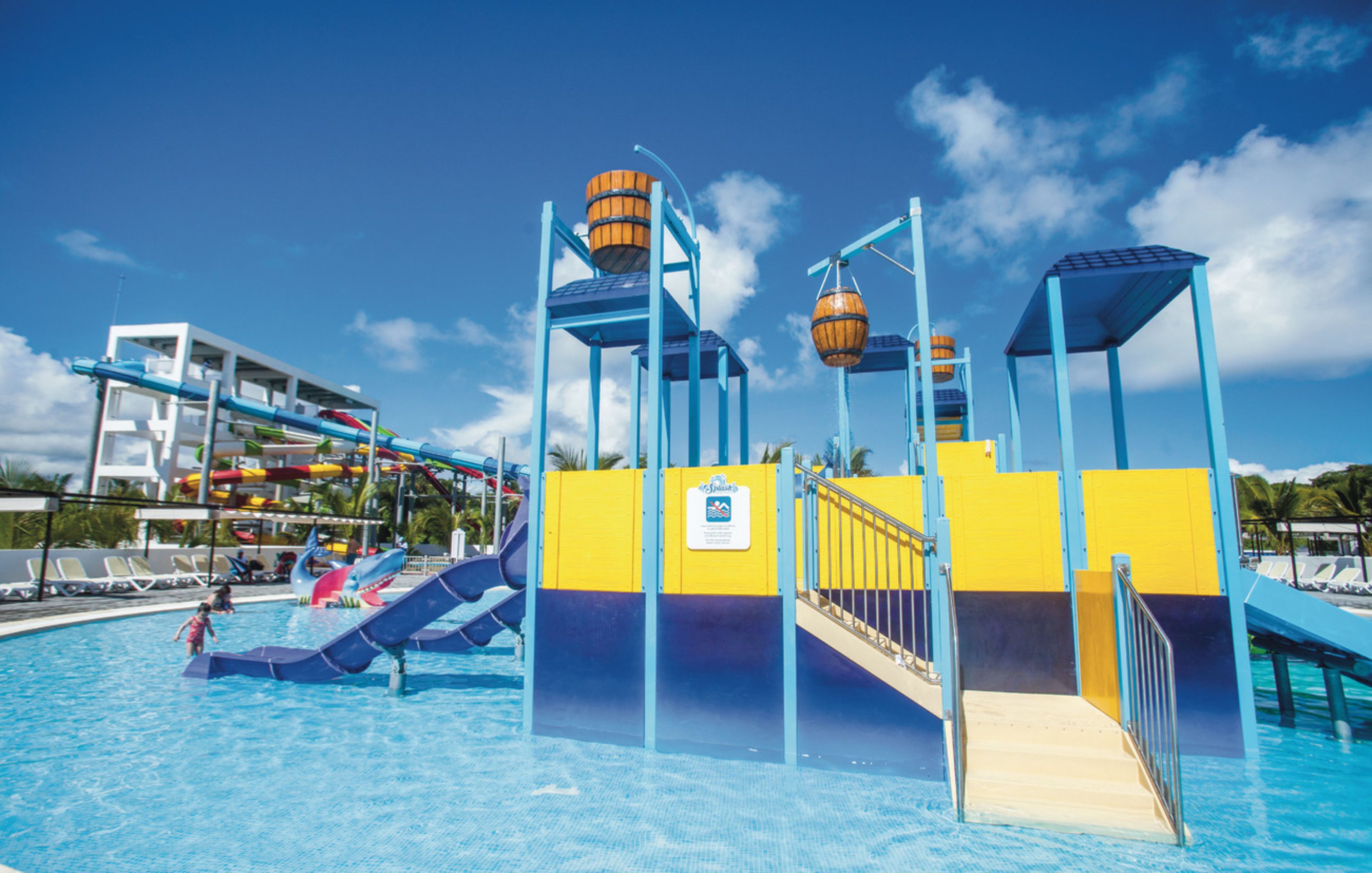 Un parc aquatique avec des toboggans, une piscine et un poste de surveillance pour les sauveteurs.