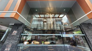 A modern lobby with a glass ceiling, seating area, and a visible elevator. - Citrus Sukhumvit 13 Nana Bangkok by Compass Hospitality (Bangkok)