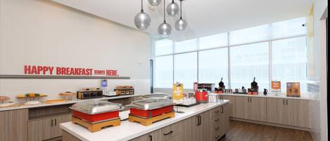 A modern breakfast area with a sign reading 'HAPPY BREAKFAST STARTS HERE.'