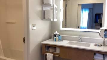 A bathroom with a white sink, mirror, and towel rack.