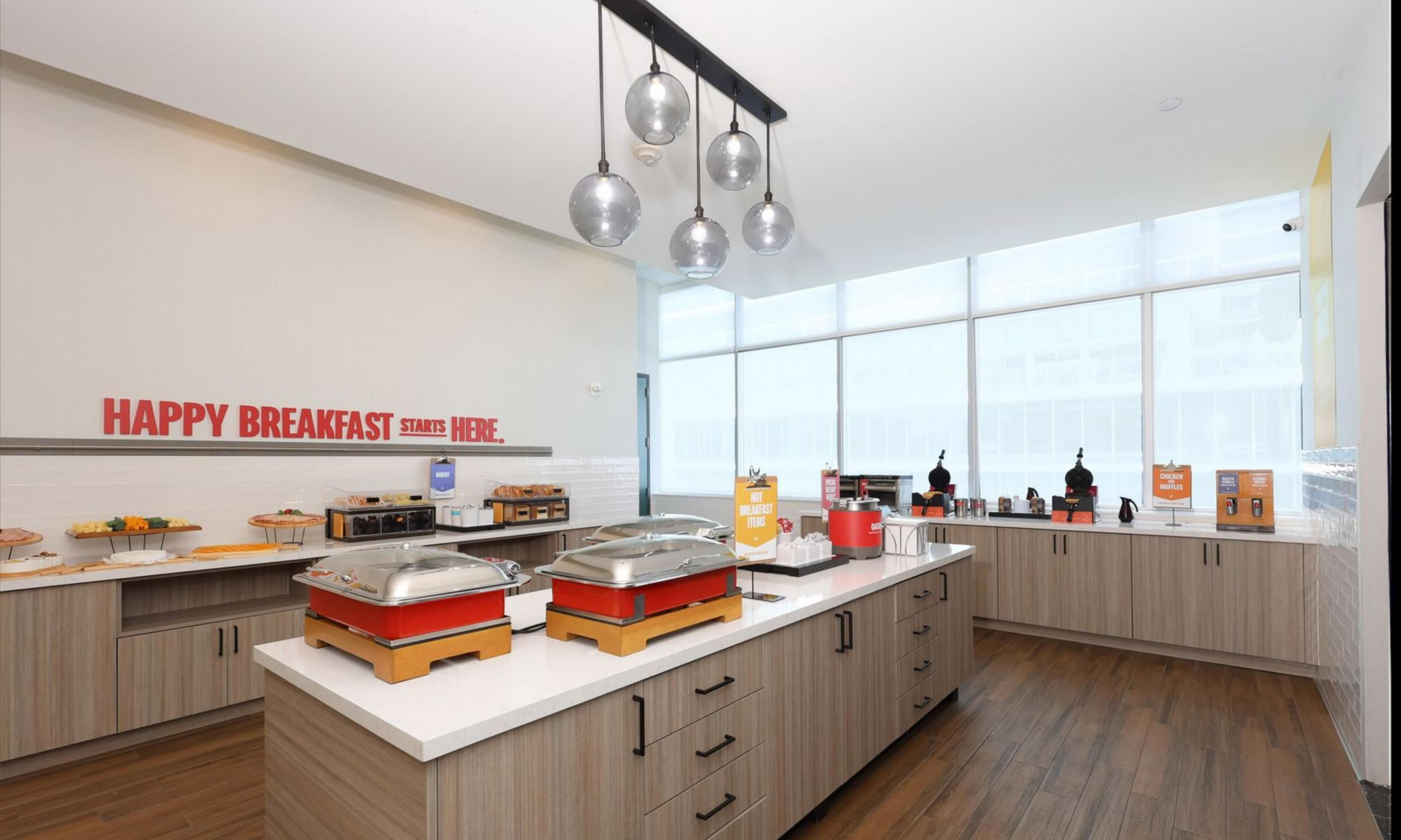 Uma área de café da manhã moderna com uma placa que diz 'HAPPY BREAKFAST STARTS HERE'.