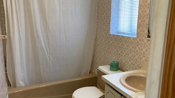 Ein Badezimmer mit Badewanne, Toilette und Waschbecken.