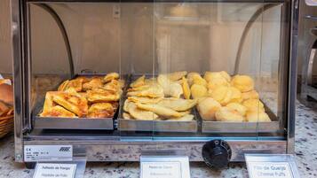 Una vitrina con diversas opciones de productos horneados, con etiquetas en portugués, incluyendo hojaldres de pollo, pasta de carne y bocadillos de queso.