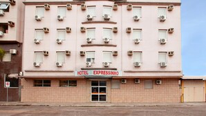 Un hôtel appelé « HOTEL EXPRESSINHO », doté de plusieurs unités de climatisation, d’une enseigne et d’une entrée fermée par un portail.