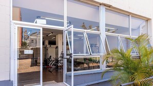 A building with large glass windows, a staircase leading to the entrance, and a potted plant on the right. - Hotel Suárez Executive Novo Hamburgo (Novo Hamburgo)