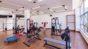 A gym with various exercise equipment, large windows, and a wooden floor. - Hotel Suárez Executive Novo Hamburgo (Novo Hamburgo)