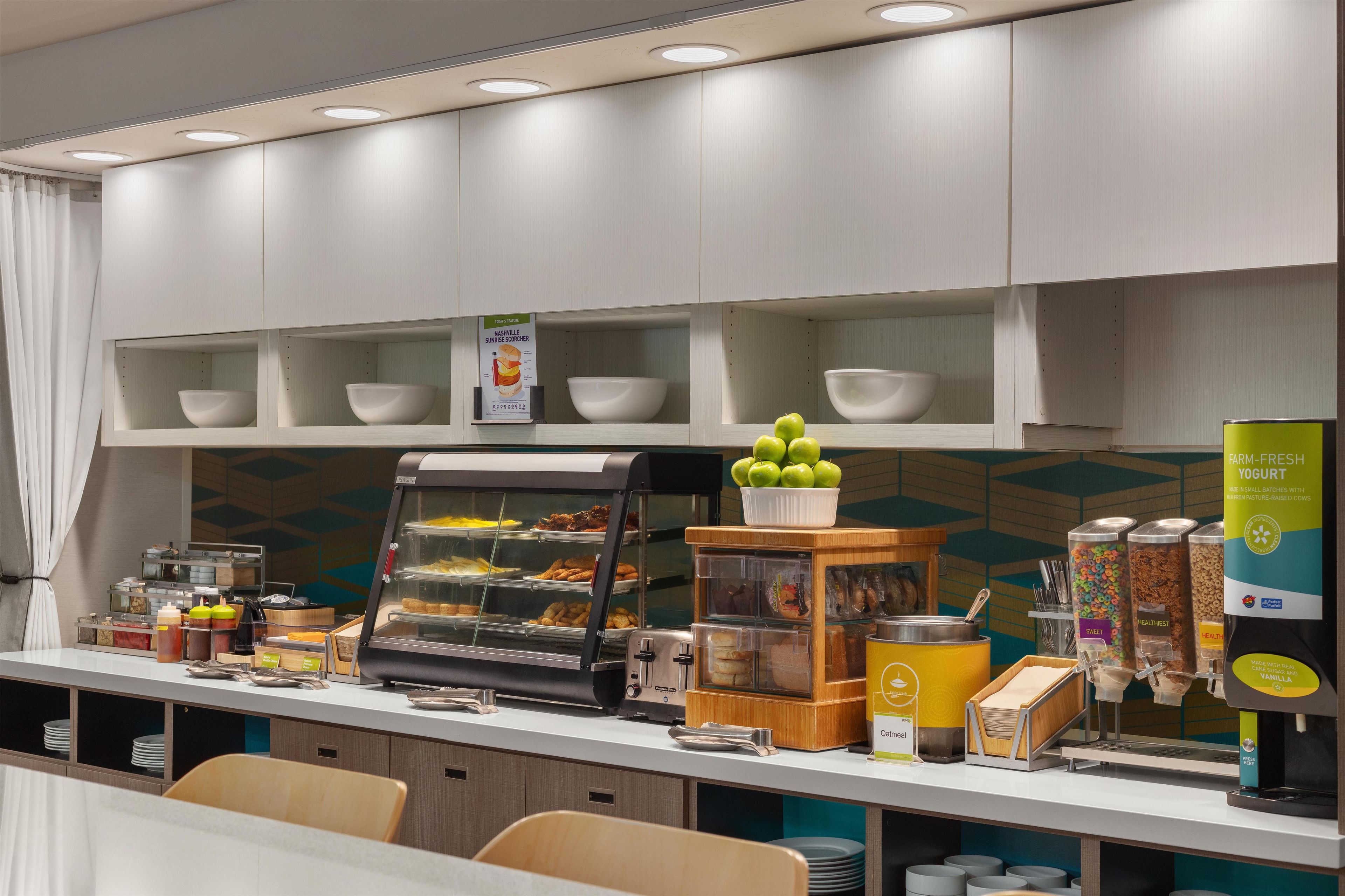 Ein Frühstücksbuffet mit verschiedenen Speisen, darunter eine Auswahl an Gebäck und eine Kaffeemaschine.
