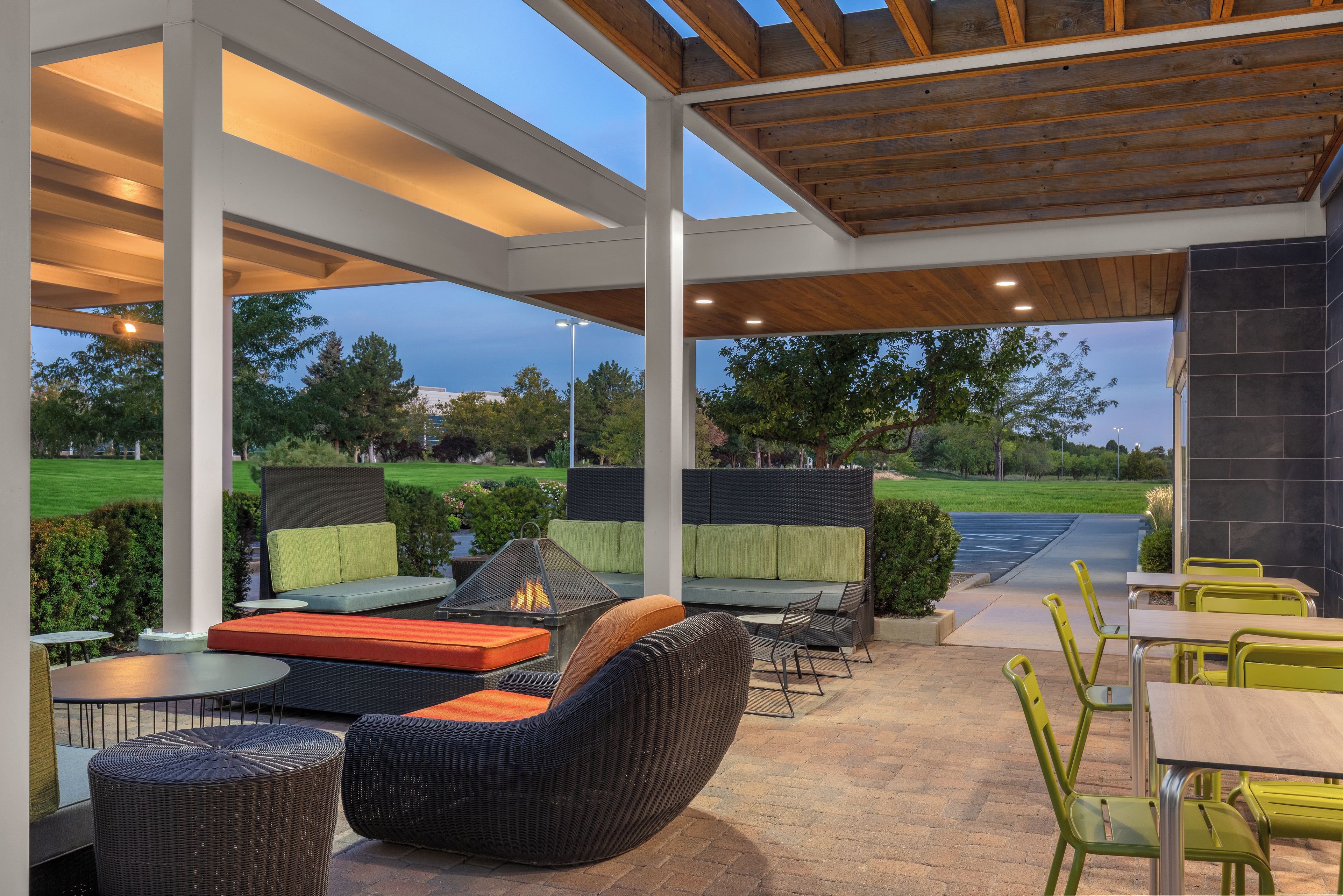 Un espace extérieur aménagé en terrasse, avec des sièges, un foyer et une vue sur le paysage environnant.