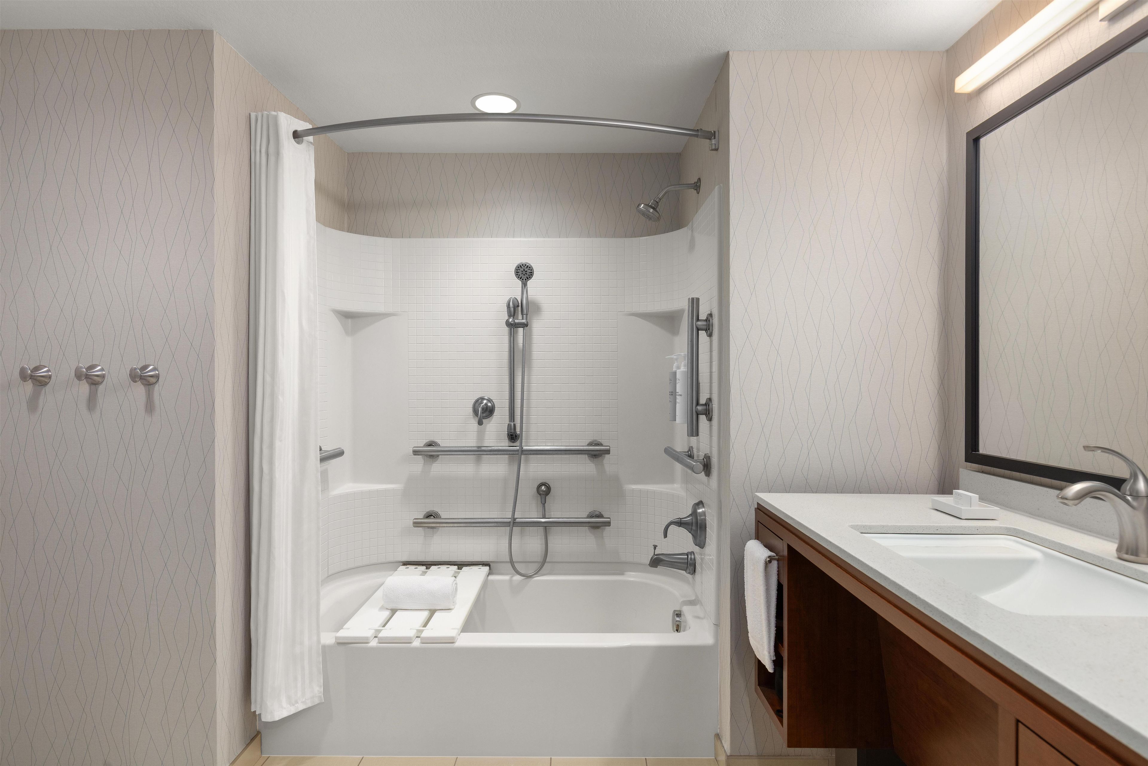 A modern bathroom with a walk-in shower, a bathtub, and a vanity with a mirror.