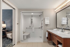 A modern bathroom with a shower, toilet, and vanity.