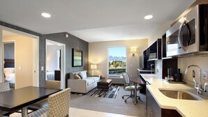 A modern kitchen with a large island, built-in appliances, and a view of mountains. - Home2 Suites by Hilton Salt Lake City/West Valley City, UT (West Valley City)