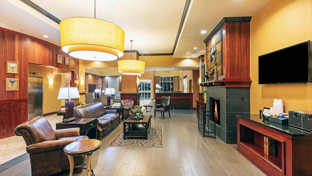 A spacious lobby with leather sofas, a coffee table, and a fireplace.