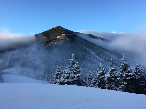 A snow-covered mountain with a clear sky and a forest in the foreground. - Cadence Lodge at Whiteface (Wilmington)