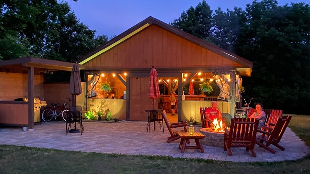 A wooden cabin with a patio area featuring outdoor seating and a fire pit. - Cadence Lodge at Whiteface (Wilmington)