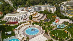 An aerial view of a resort with multiple swimming pools, a basketball court, and a large hotel building. - Kaya Side - All Inclusive (Manavgat)