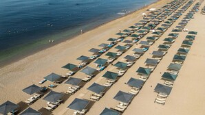 An aerial view of a beach with rows of beach umbrellas and lounge chairs. - Kaya Side - All Inclusive (Manavgat)
