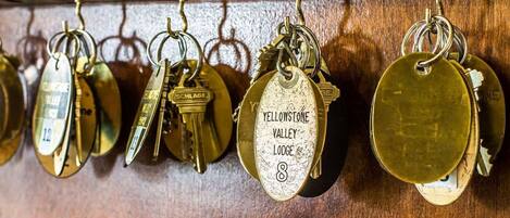 A row of keys hanging on a wooden rack.