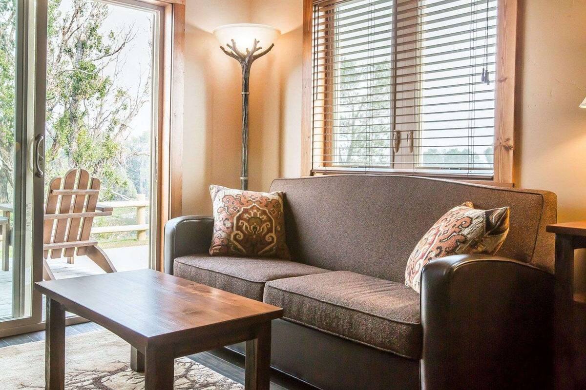 A cozy living room with a sofa, a coffee table, and a lamp.