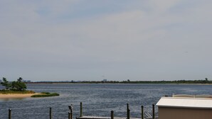 A waterfront view with a dock and a building in the foreground. - Surfside Motel (Howard Beach)
