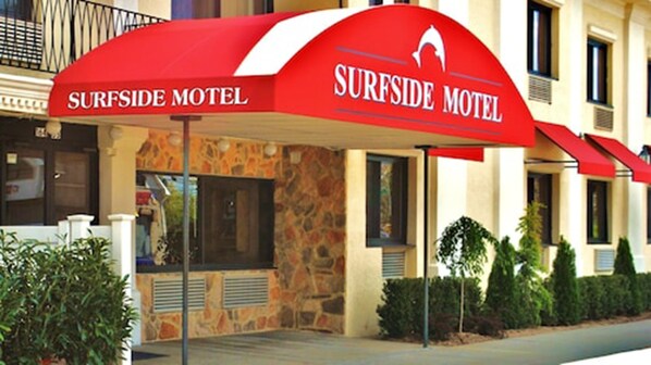 Welcome to Surfside Motel, featuring a modern entrance with a red awning and stylized surfboard logo.
