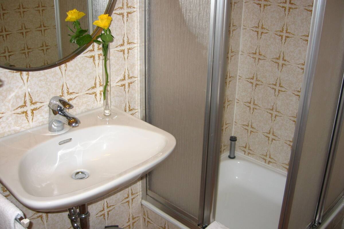 Une salle de bain avec un lavabo, un miroir et une douche.