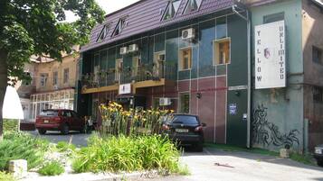Un edificio con fachada verde, varias ventanas y un letrero que dice "YELLOW UNLIMITED".