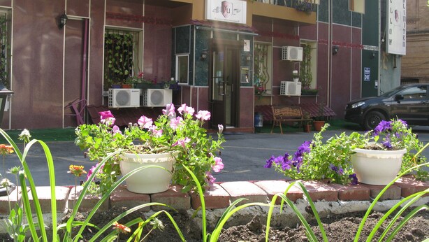 A building with a balcony, air conditioning units, and potted plants. - YELLOW UNLIMITED HOTEL 4 (Kharkiv)