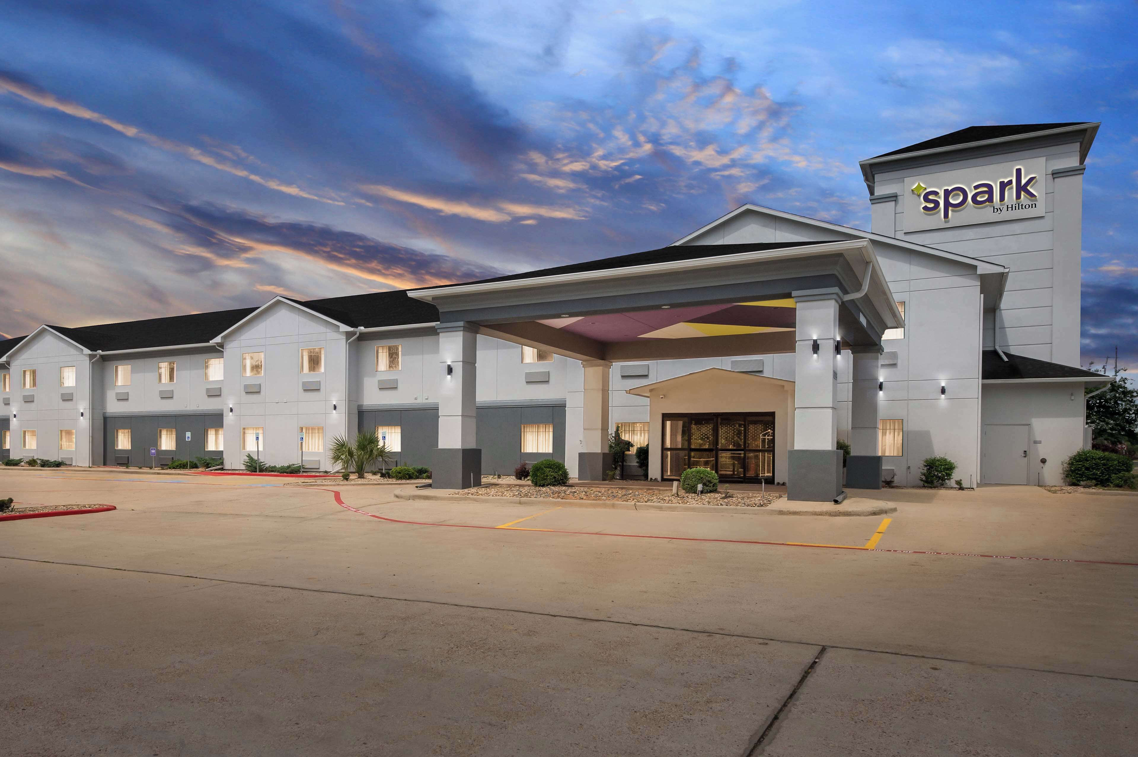 A hotel with a modern design, featuring a covered entrance and multiple windows.